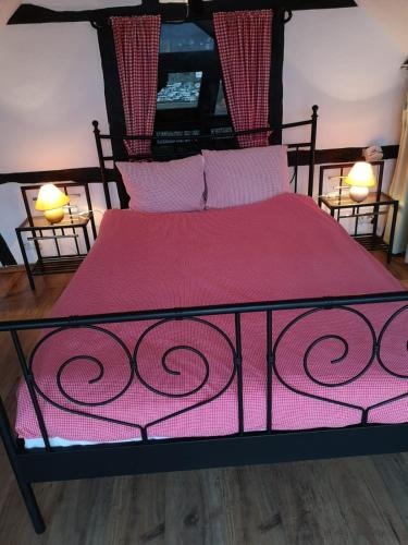 a bedroom with a bed with a red blanket and two lamps at Ferienhof Schmickerath in Simmerath