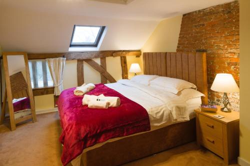 a bedroom with a large bed and a brick wall at Oak Cottage in Thorndon