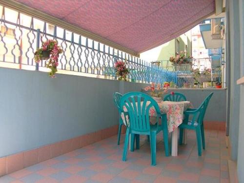 einen Tisch und Stühle auf einer Terrasse mit Balkon in der Unterkunft Appartamenti Padoan in Sottomarina