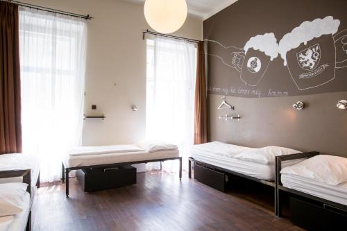 a room with three beds and a wall with a picture of popcorn at Sophie's Hostel in Prague