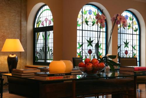 a table with a bowl of fruit in front of stained glass windows at Hotel Rector in Salamanca