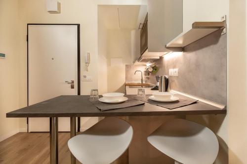 a kitchen with a table and two white chairs at Alessia's Building- Affori FN in Milan