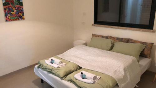 Un pequeño dormitorio con una cama con toallas. en צימר בעמק, en Kefar Ruppin
