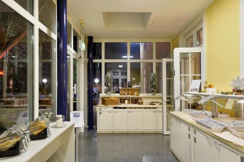 ハノーファーにあるベッドンバジェット エキスポ ホステル ルームズの白いキャビネットと窓付きの広いキッチン