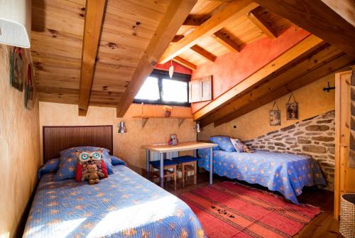 um quarto com duas camas e um urso de peluche sentado na cama em La Casita de Zalama em San Pelayo - Merindad de Montija