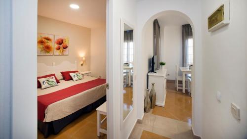 a bedroom with a bed and a room with a table at Leo San Bruno in Isla Canela