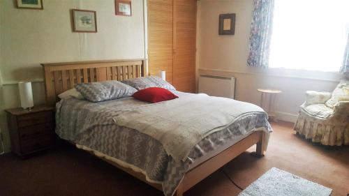 a bedroom with a bed with a red pillow on it at TopHeavy Cottage Mevagissey in Mevagissey