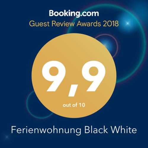 a sign that reads guest review awards with a yellow circle at Ferienwohnung Black White in Raubling