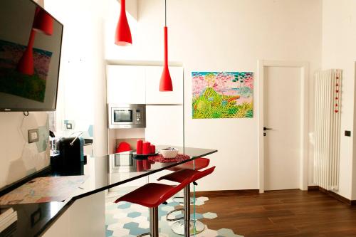 une cuisine avec un comptoir et deux tabourets de bar rouge dans l'établissement Casa Veniero, à Rome