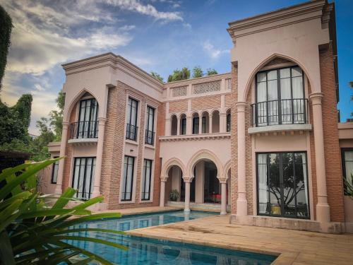 una casa grande con piscina frente a ella en The Ryad Rayong en Mae Pim