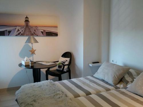 ein Schlafzimmer mit einem Bett und einem Tisch mit einer Lampe in der Unterkunft Apartamento Nules Experience in Mascarell