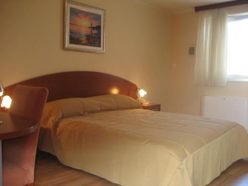 a bedroom with a bed and a table and a window at Apartments Silvana in Trogir