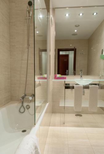 ein Badezimmer mit Dusche, Badewanne und Waschbecken in der Unterkunft Zenit Lisboa in Lissabon
