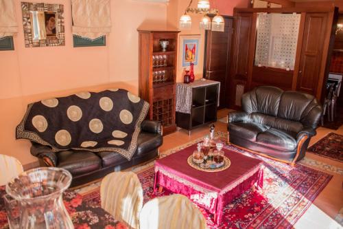 a living room with leather chairs and a table at 4-seasons pool villa near Meteora in Tríkala