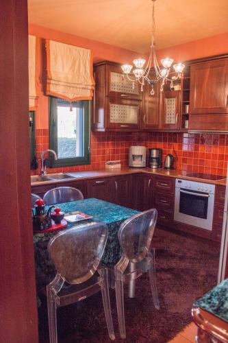 a kitchen with a table and chairs in it at 4-seasons pool villa near Meteora in Tríkala