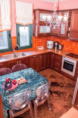 a kitchen with a table with chairs and a sink at 4-seasons pool villa near Meteora in Tríkala
