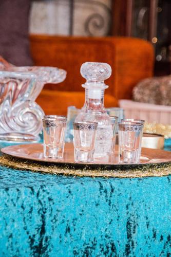 a tray with glasses and a bottle on a table at 4-seasons pool villa near Meteora in Tríkala