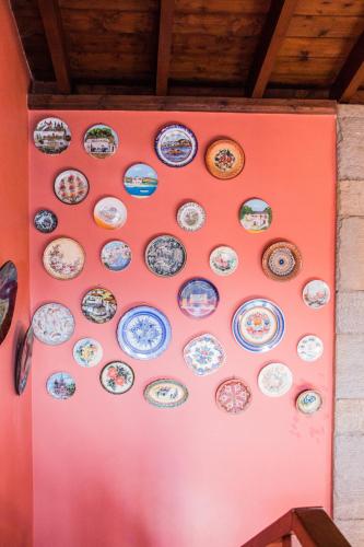 a wall full of plates on a pink wall at 4-seasons pool villa near Meteora in Tríkala