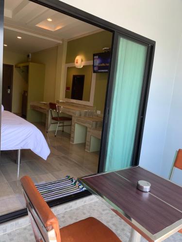 a room with a table and a bed and a dining room at โรงแรมมาลินี in Surin