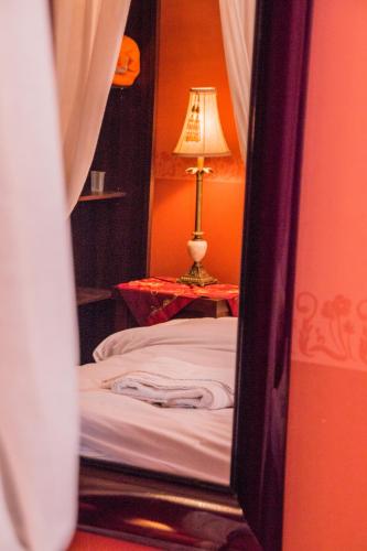 a bedroom with a bed and a lamp in a mirror at 4-seasons pool villa near Meteora in Tríkala
