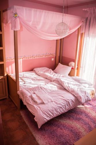 a bed with a canopy in a bedroom at 4-seasons pool villa near Meteora in Tríkala