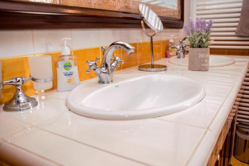 a bathroom counter with a white sink with two sinksyss at 4-seasons pool villa near Meteora in Tríkala