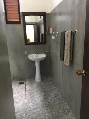 a bathroom with a sink and a mirror at Villa N in Unawatuna