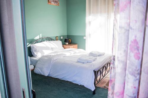 a bedroom with two beds with white sheets and a window at 4-seasons pool villa near Meteora in Tríkala