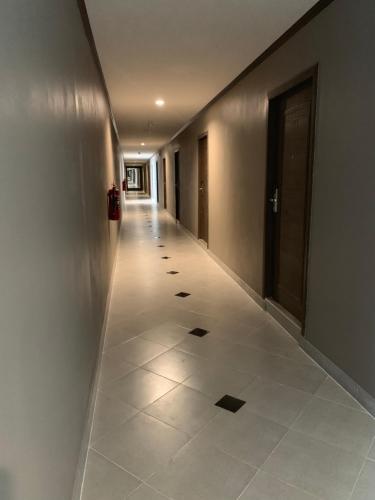 a hallway with a long hallway with a tile floor at โรงแรมมาลินี in Surin