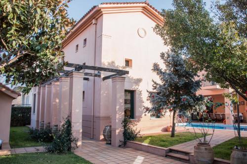 a white house with a courtyard and a pool at 4-seasons pool villa near Meteora in Tríkala