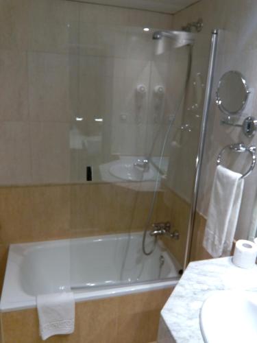 a bathroom with a shower and a tub and a sink at Moderno in Barcelona
