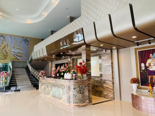 a lobby with a staircase and a flower shop at โรงแรมมาลินี in Surin