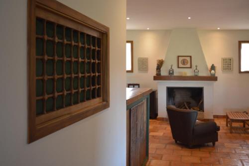 a living room with a chair and a fireplace at Casa Rural Pilón del Fraile in Oropesa