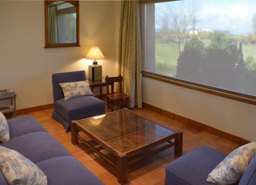 a living room with couches and a table and a window at Casa Rural Pilón del Fraile in Oropesa