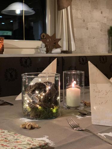 a table with a candle and a centerpiece on it at Heutaler Hof - Hotel im Naturidyll in Unken