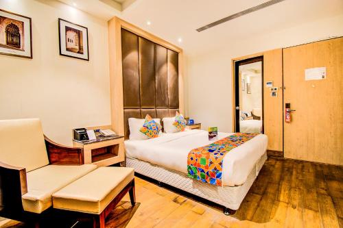 ein Hotelzimmer mit einem Bett und einem Stuhl in der Unterkunft FabHotel Prime V Hazratganj in Lucknow