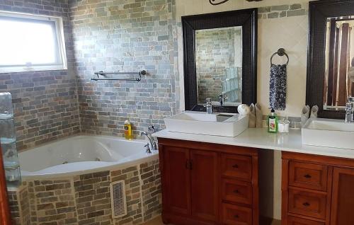 a bathroom with two sinks and a bath tub at White Sands Anguilla - Sea in Blowing Point Village
