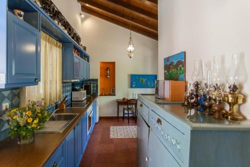 a large kitchen with blue cabinets and a sink at Metohi Georgila in Maleme