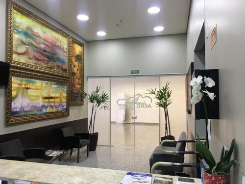 a lobby of a store with chairs and plants at Hotel Aero Sleep Campinas in Campinas