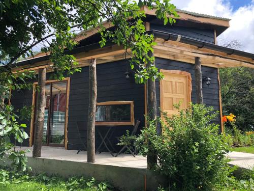 a small blue house with a wooden door at Cabanas Senderos Puyuhuapi in Puerto Puyuhuapi