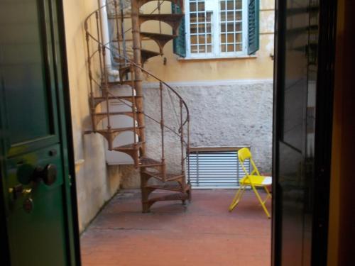een wenteltrap in een kamer met een gele stoel bij Il rifugio di sav. in Rome