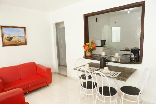 a living room with a red couch and a table at Apartamento 2 quartos in Laguna