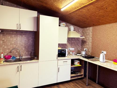 a kitchen with white cabinets and a sink at Hostel Gulliver in Uzhhorod