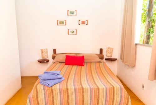 - une chambre avec un lit et une couverture colorée dans l'établissement Pousada Jardim da Nova Era, à Alto Paraíso de Goiás