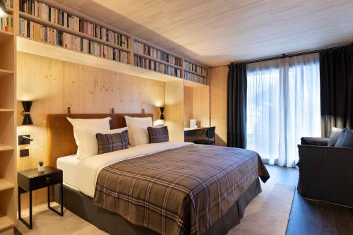 a hotel room with a bed and bookshelves at St-Alban Hotel & Spa in La Clusaz