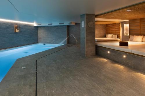 a hotel room with a swimming pool and a bed at St-Alban Hotel & Spa in La Clusaz