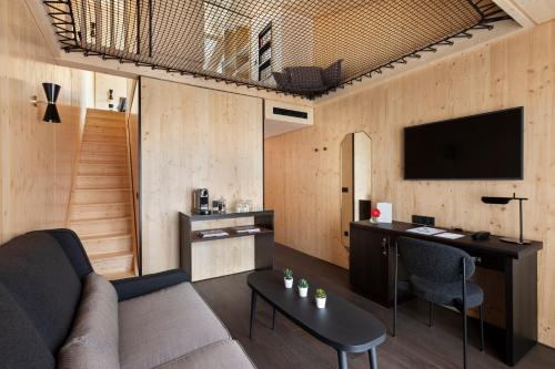 a living room with a couch and a desk at St-Alban Hotel & Spa in La Clusaz