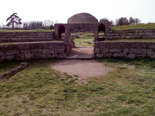 an old stone building with an arch in a field at Hotel Grazia Eboli in Eboli