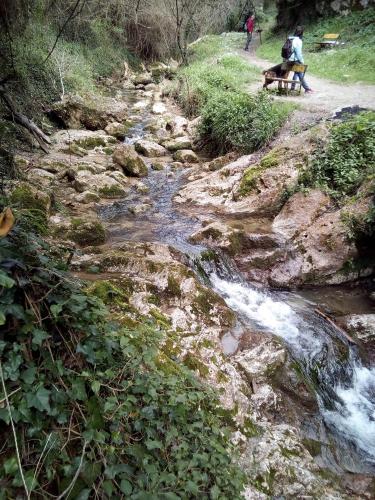 two people sitting on a bench next to a stream at Hotel Grazia Eboli in Eboli