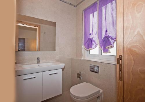 a bathroom with a sink and a toilet and a window at Crescent Court F in St. Paul's Bay